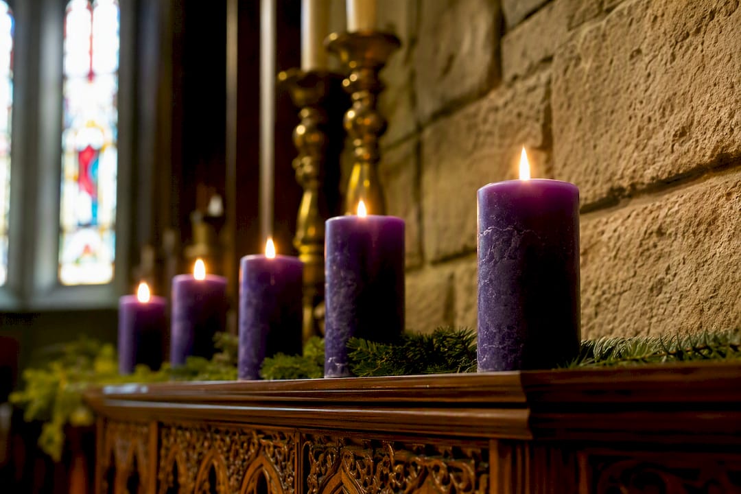 Lila liturgikus gyertyák meggyújtva a templomban